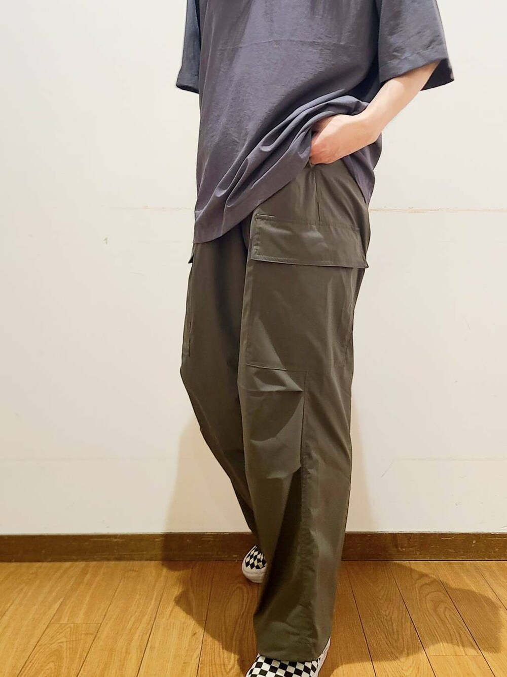 ブラック系のスニーカー、グリーン系のその他パンツ、グレー系のポロシャツを着用したメンズの春コーディネートの4枚目の写真