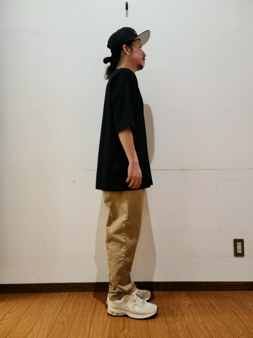ブラック系のTシャツ/カットソー、ベージュ系のその他パンツ、ブラック系のキャップを着用したメンズの春コーディネートの2枚目の写真