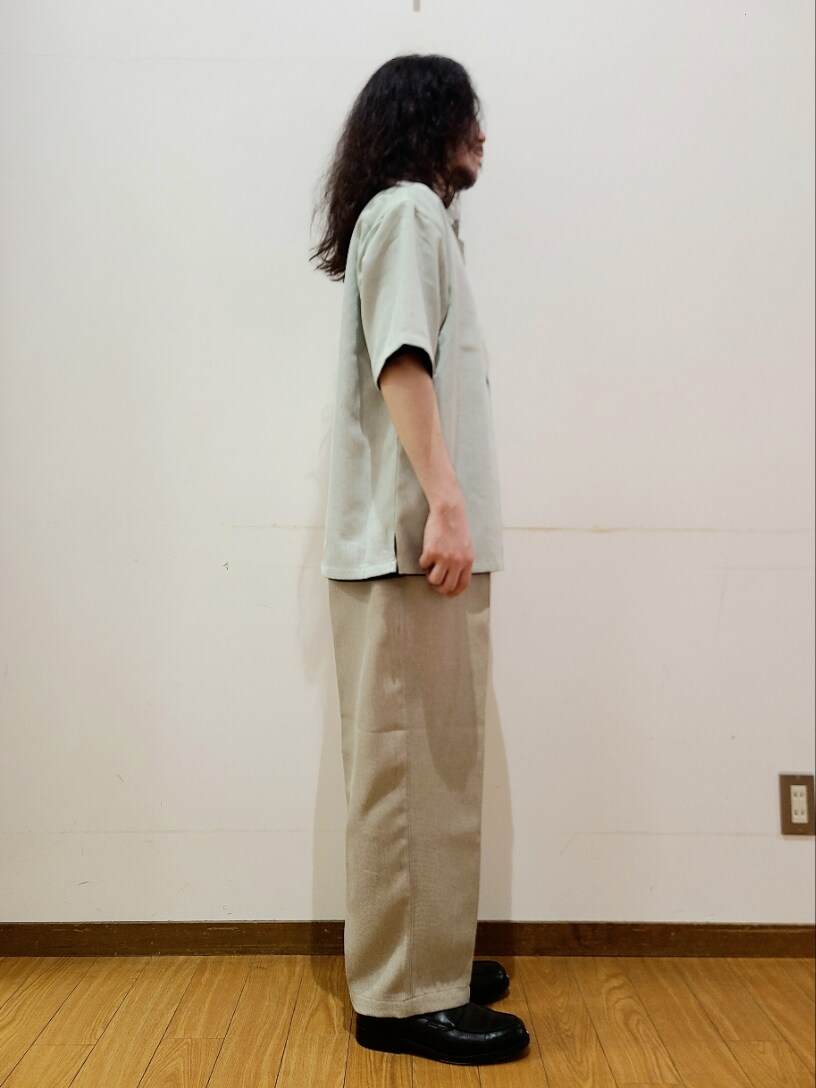 ベージュ系のスラックス、ブラック系のTシャツ/カットソー、グリーン系のシャツ/ブラウスを着用したメンズの夏コーディネートの2枚目の写真