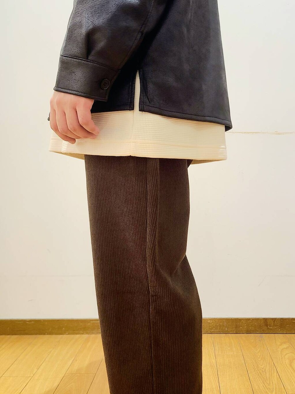 ブラック系のブルゾン、ブラウン系のその他パンツ、ホワイト系のTシャツ/カットソーを着用したメンズの冬コーディネートの6枚目の写真
