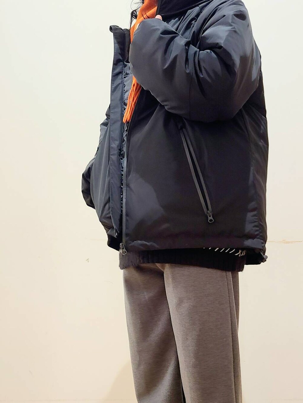 グレー系のその他パンツ、ブラック系のニット/セーター、ブラック系のダウンジャケット/コートを着用したメンズの冬コーディネートの4枚目の写真