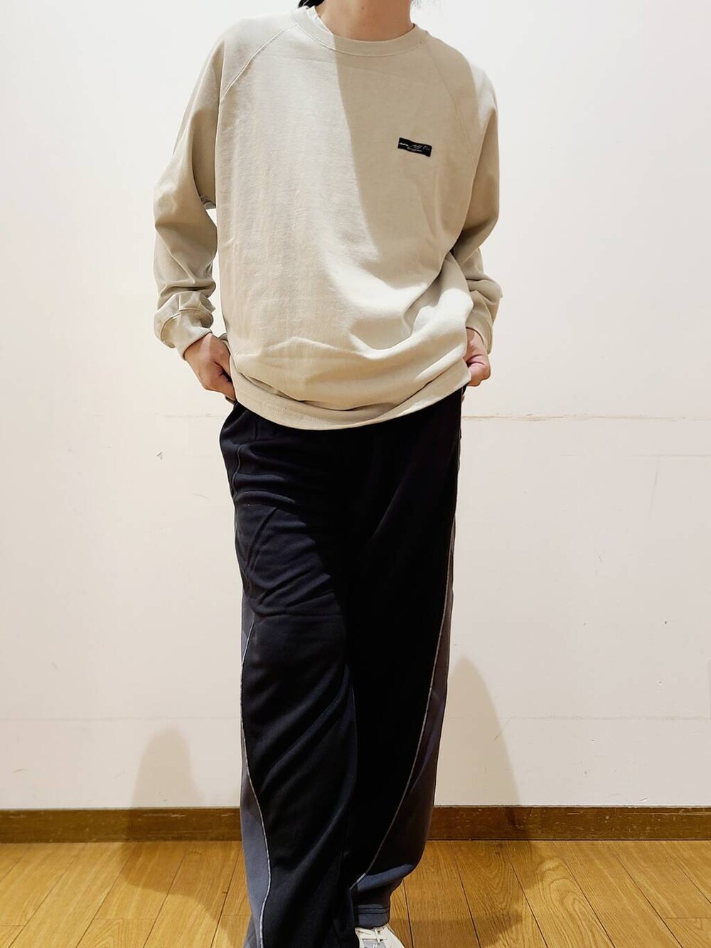 ベージュ系のTシャツ/カットソー、ブラック系のその他パンツを着用したメンズの秋コーディネートの7枚目の写真