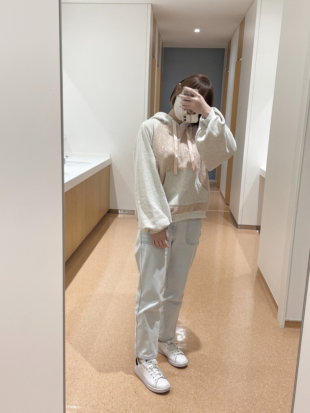 ホワイト系のデニムパンツ、ホワイト系のスニーカー、ホワイト系のブルゾンを着用したレディースの冬コーディネートの2枚目の写真