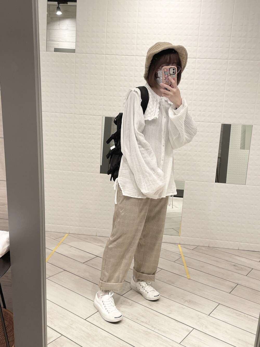 ベージュ系のパンツ、ホワイト系のスニーカー、ホワイト系のシャツ/ブラウスを着用したレディースの秋コーディネートの2枚目の写真