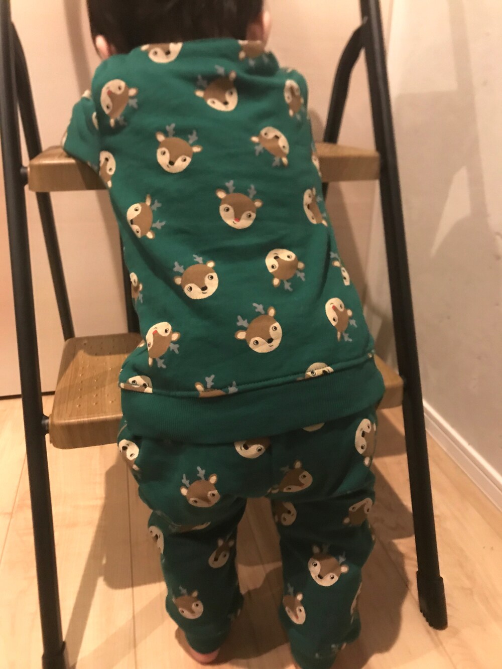 グリーン系のルームウェアを着用したキッズの秋コーディネートの2枚目の写真