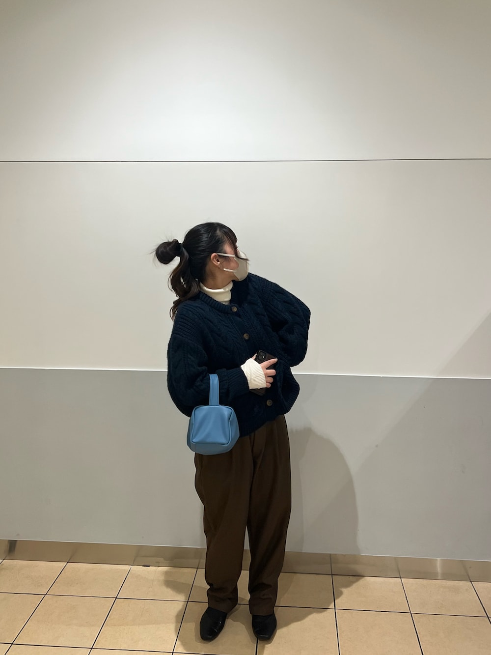 ブラウン系のセットアップ、レッド系のニット/セーター、ブルー系のショルダーバッグを着用したレディースの春コーディネートの2枚目の写真