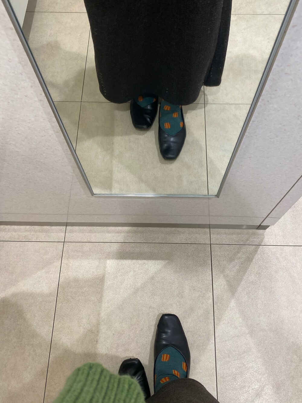 ブラック系のボストンバッグ、グリーン系のニット/セーター、ブラック系のスカートを着用したレディースの冬コーディネートの3枚目の写真