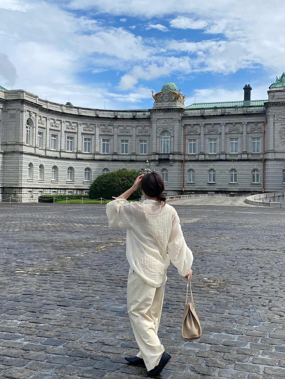 ベージュ系のトートバッグ、ホワイト系のシャツ/ブラウス、ホワイト系のスラックスを着用したレディースの夏コーディネートの3枚目の写真