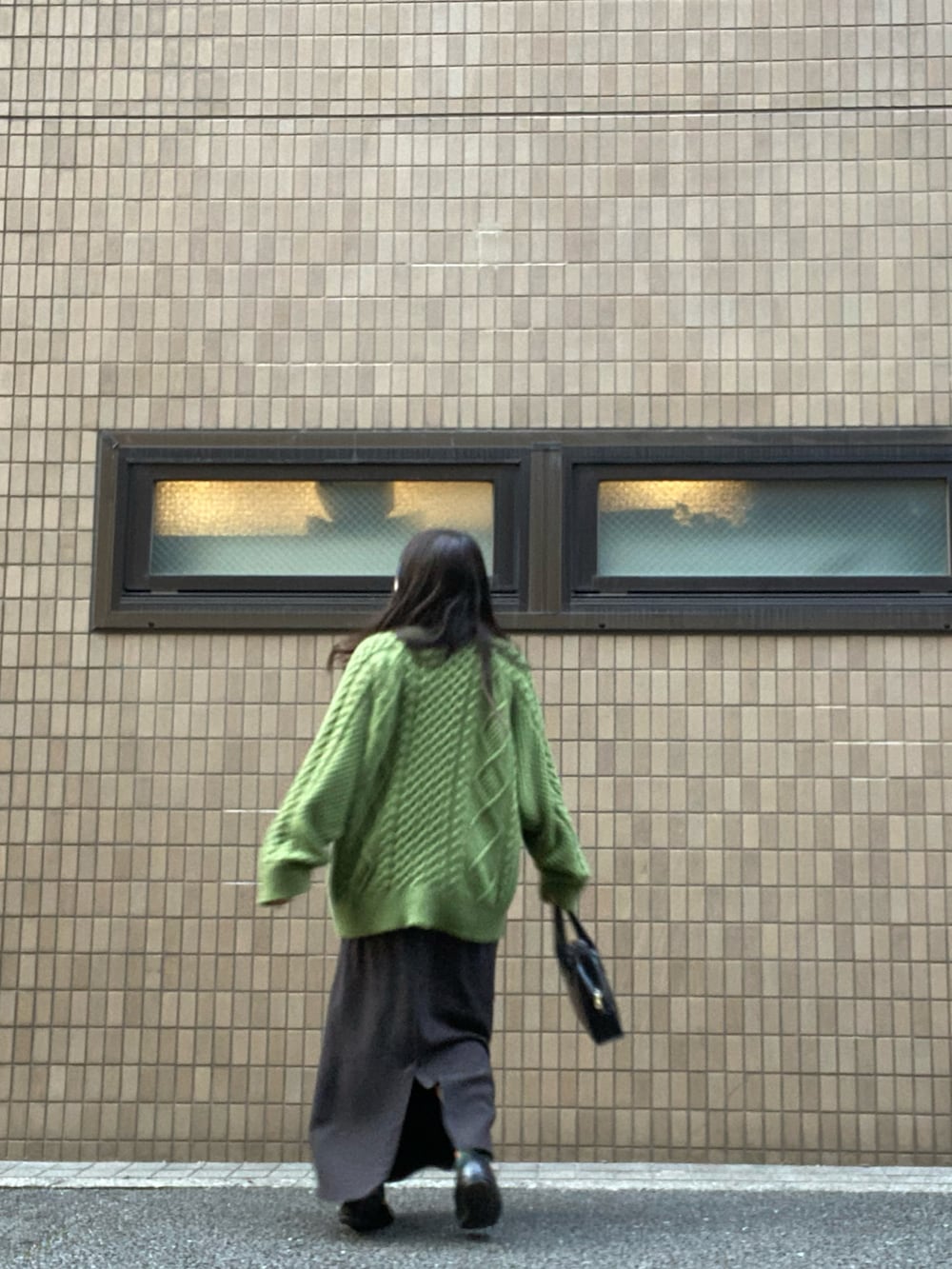 ブラック系のボストンバッグ、グリーン系のニット/セーター、ブラック系のスカートを着用したレディースの冬コーディネートの2枚目の写真