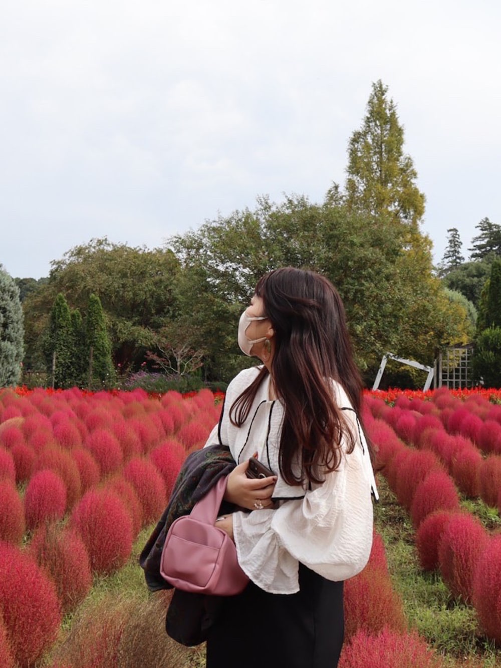 パープル系のテーラードジャケット、ピンク系のボストンバッグ、ホワイト系のシャツ/ブラウスを着用したレディースの秋コーディネートの2枚目の写真