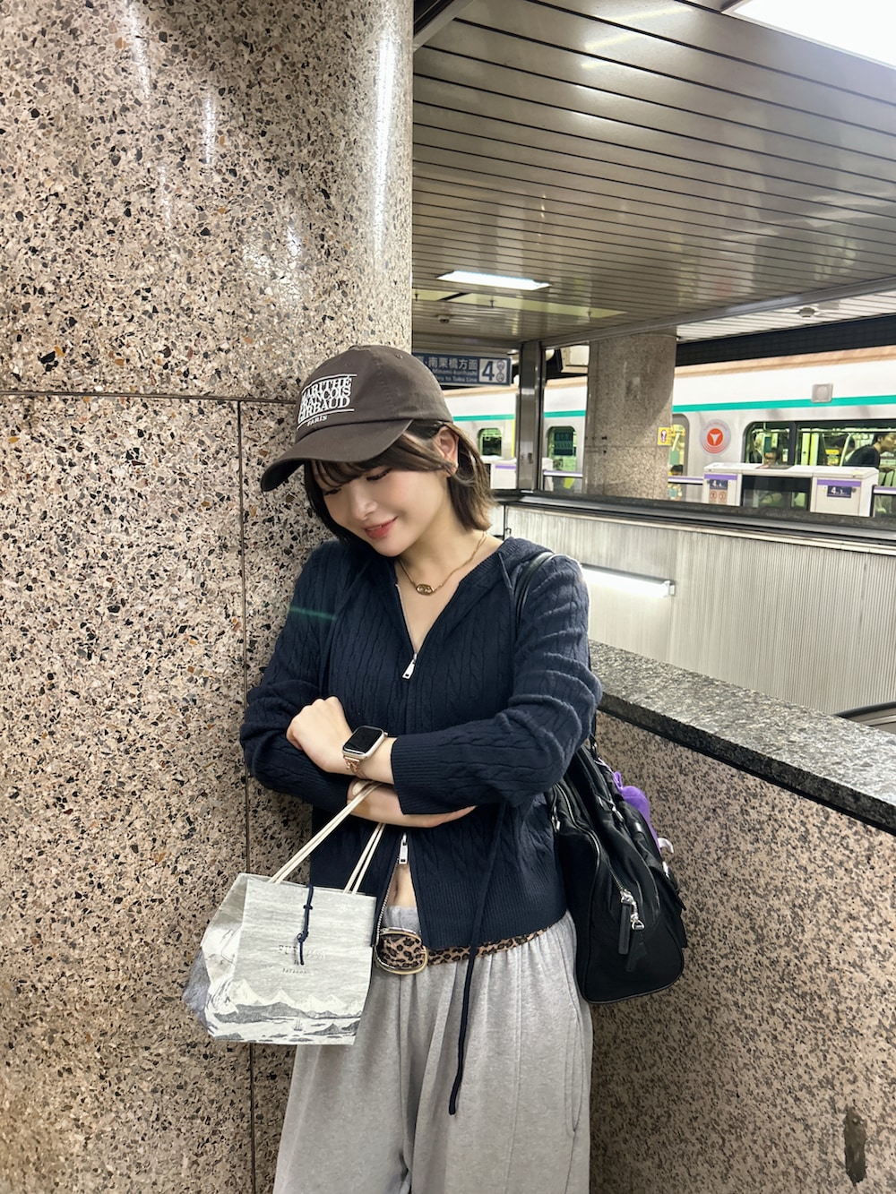 ブラウン系のスニーカー、ブラック系のトートバッグ、ブラウン系のベルトを着用したレディースの秋コーディネートの5枚目の写真