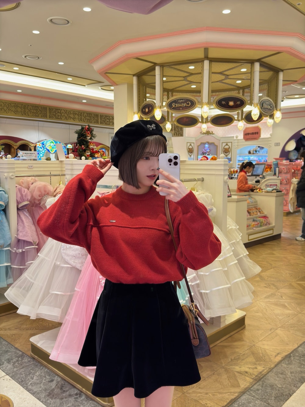 レッド系のニット/セーター、ブラック系のスカート、ブラウン系のハンドバッグを着用したレディースの冬コーディネートの4枚目の写真