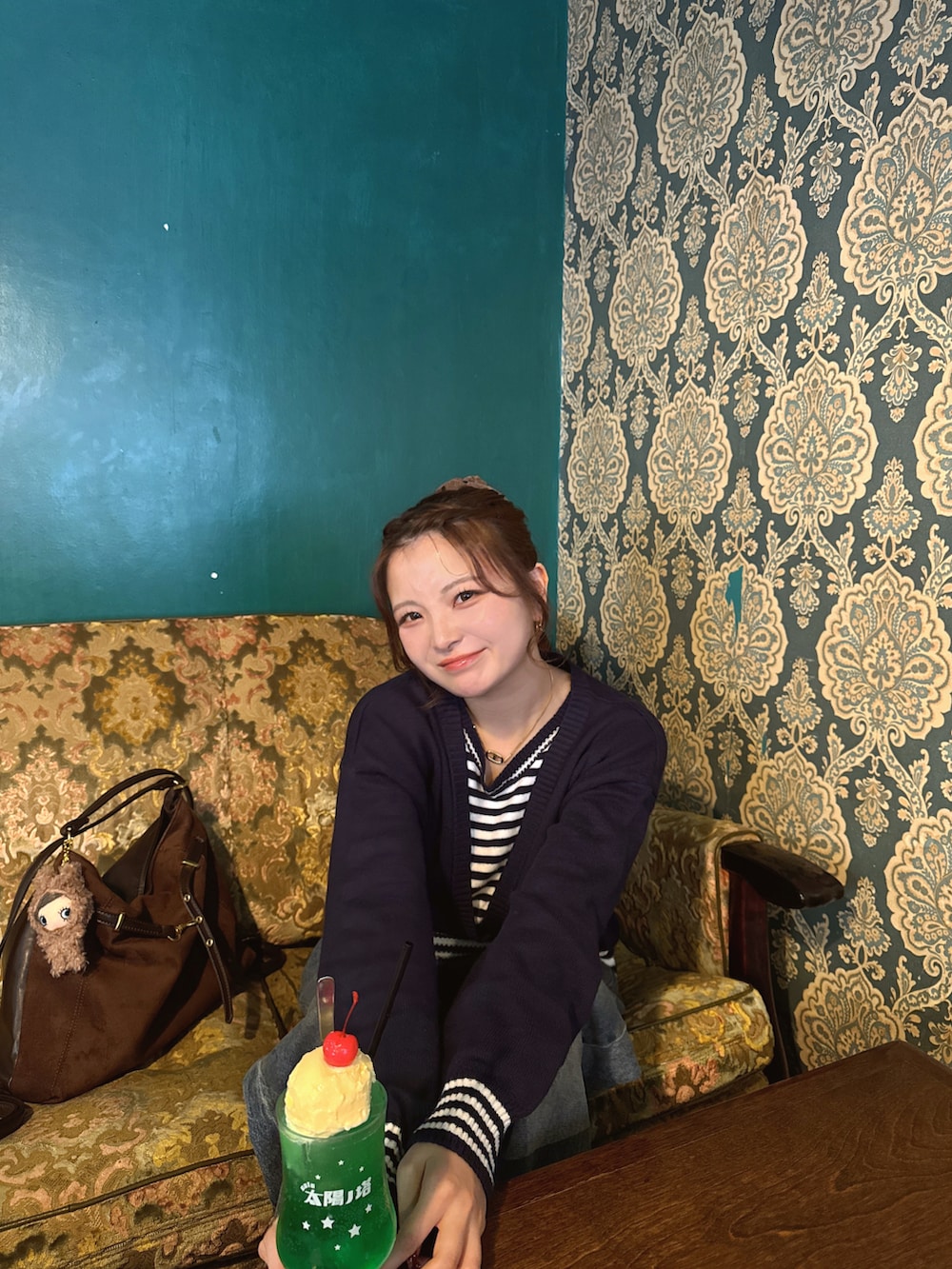 ブラック系のスニーカー、ブルー系のデニムパンツ、ブルー系のニット/セーターを着用したレディースの春コーディネートの4枚目の写真