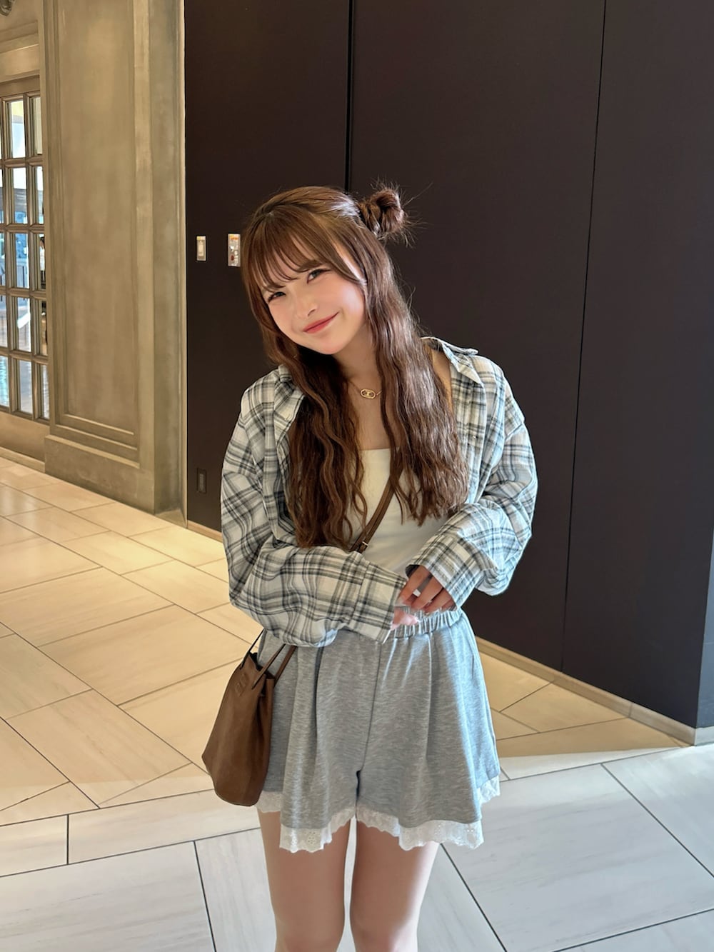 ホワイト系のスニーカー、グレー系のスウェットパンツ、ブラウン系のショルダーバッグを着用したレディースの春コーディネートの3枚目の写真