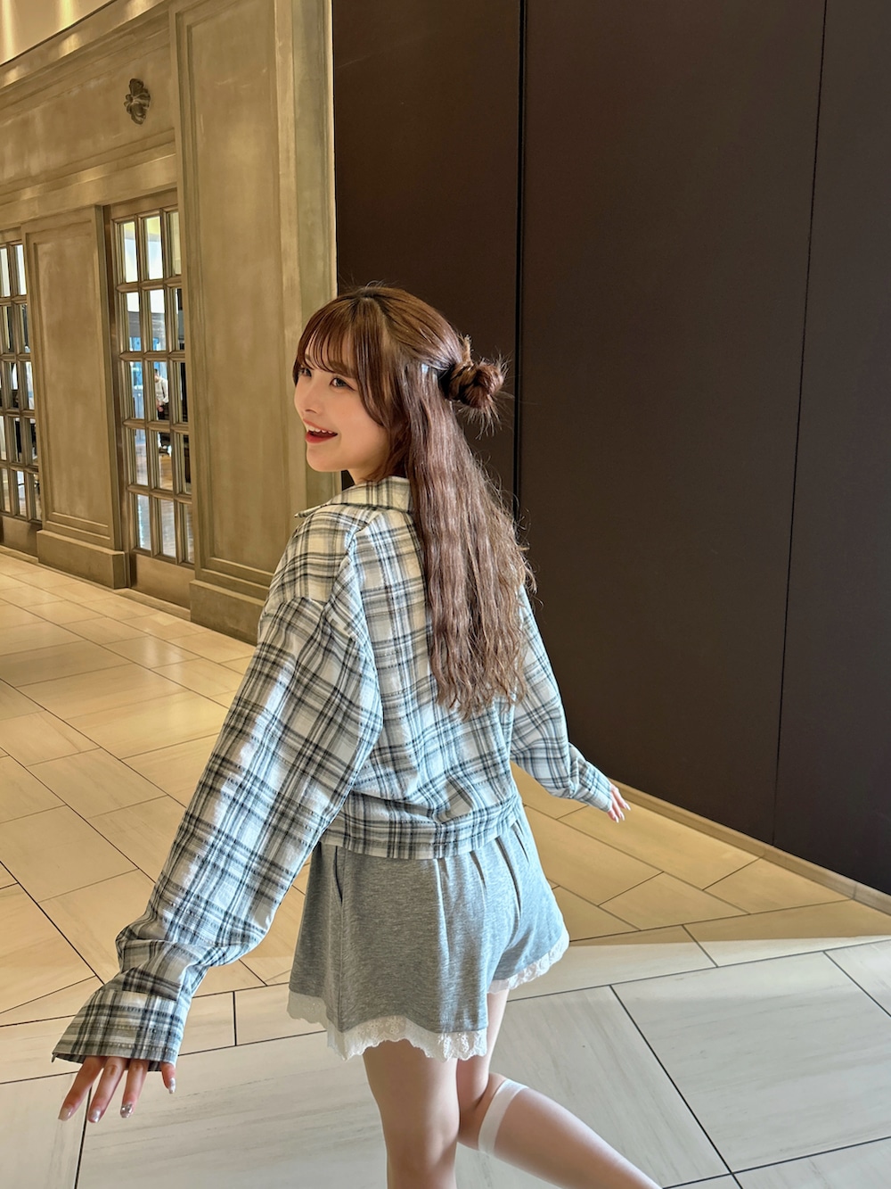 ホワイト系のスニーカー、グレー系のスウェットパンツ、ブラウン系のショルダーバッグを着用したレディースの春コーディネートの2枚目の写真