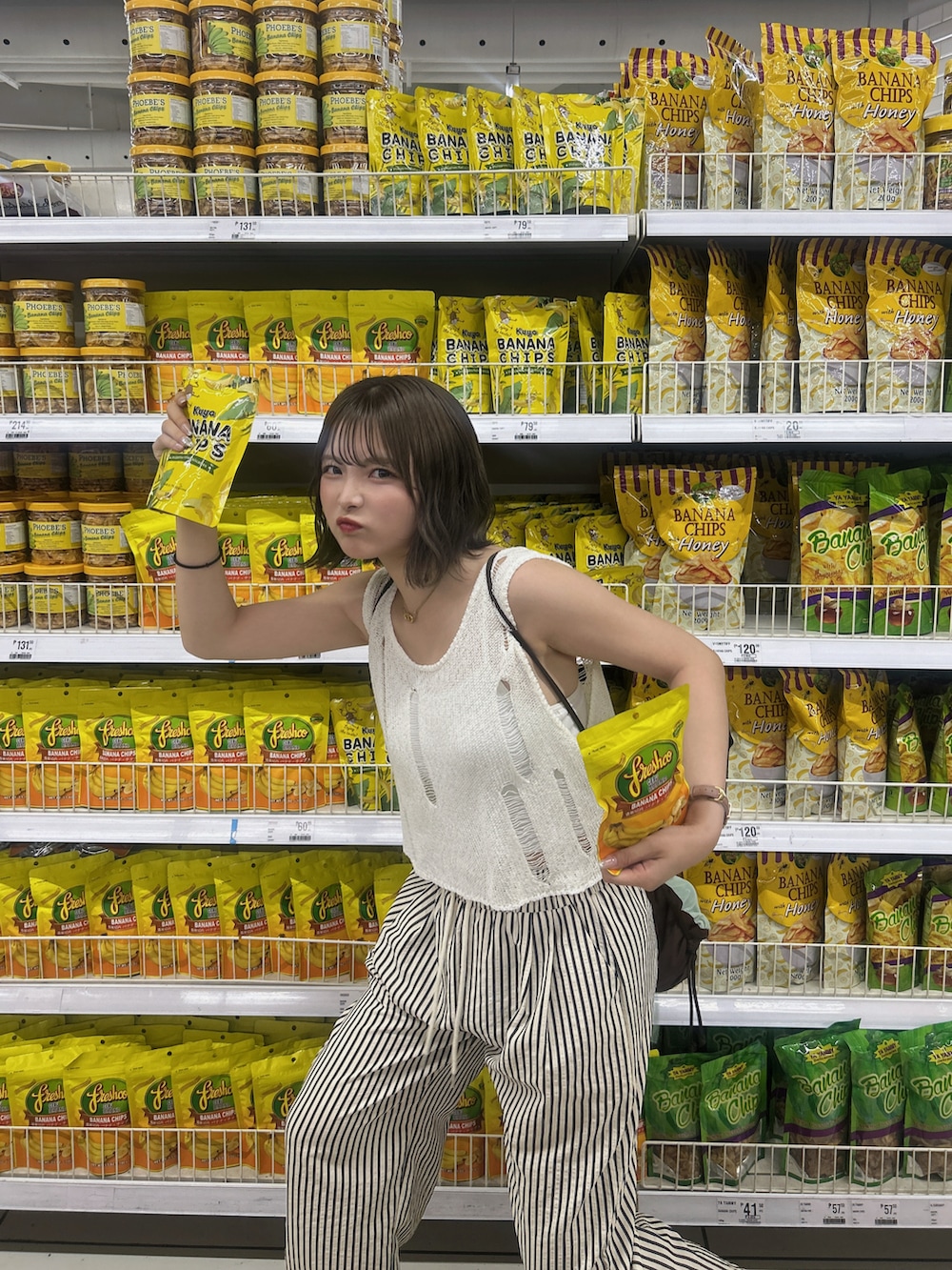 ブラウン系のバックパック/リュック、ホワイト系のスラックス、ホワイト系のベストを着用したレディースの夏コーディネートの3枚目の写真