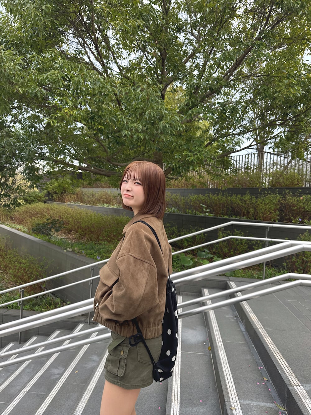 イエロー系のTシャツ/カットソー、ブラウン系のジャケット/アウター、グリーン系のパンツを着用したレディースの春コーディネートの3枚目の写真