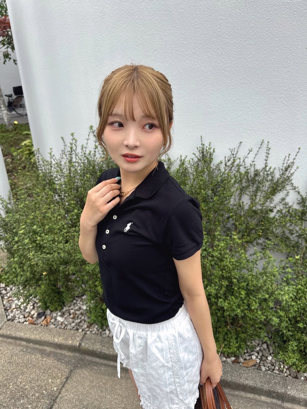 ブラック系のポロシャツを着用したレディースの夏コーディネートの2枚目の写真
