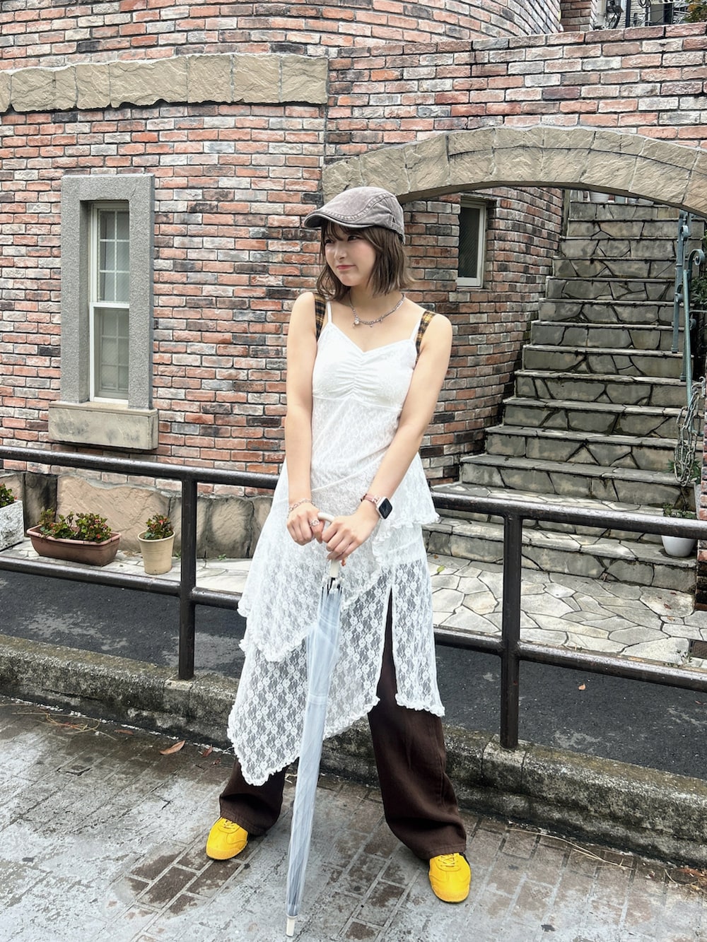 イエロー系のショルダーバッグ、ホワイト系のワンピース、イエロー系のスニーカーを着用したレディースの夏コーディネートの2枚目の写真