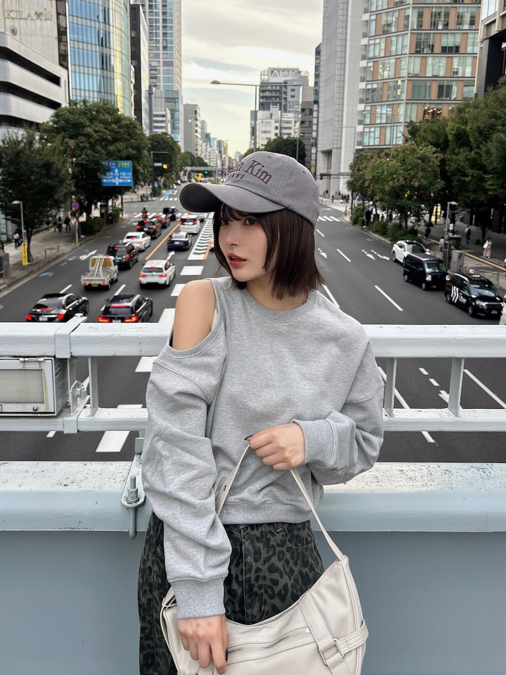 ブルー系のデニムパンツ、イエロー系のスニーカー、ホワイト系のバッグを着用したレディースの秋コーディネートの2枚目の写真