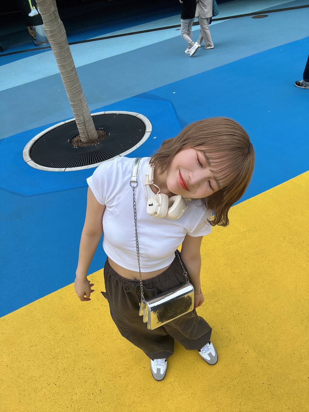 ホワイト系のTシャツ/カットソー、ブラック系のシューズアクセサリー、ホワイト系のスニーカーを着用したレディースの夏コーディネートの3枚目の写真