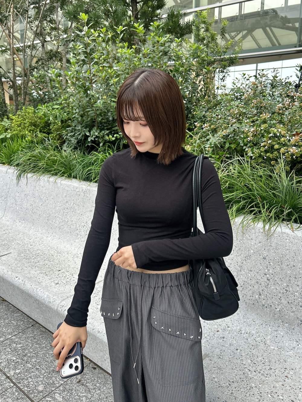 グレー系のスラックス、ベージュ系のパーカー、ブラック系のトートバッグを着用したレディースの秋コーディネートの5枚目の写真