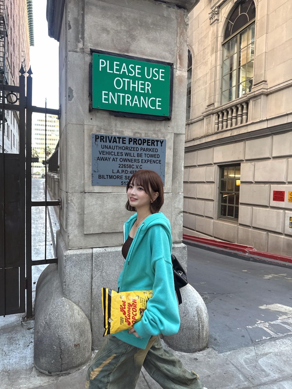 グリーン系のパーカー、ホワイト系のスニーカー、ブルー系のデニムパンツを着用したレディースの冬コーディネートの4枚目の写真