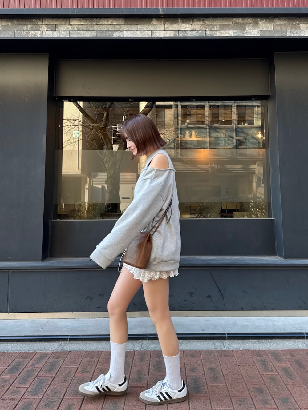 ホワイト系のスニーカー、グレー系のスウェットを着用したレディースの春コーディネートの3枚目の写真