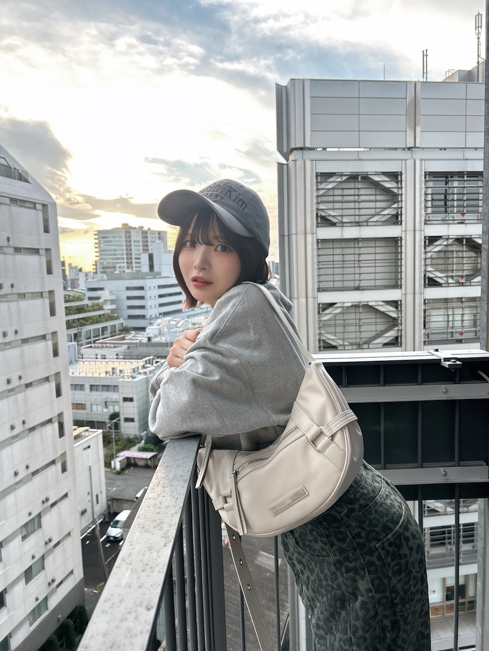 ブルー系のデニムパンツ、イエロー系のスニーカー、ホワイト系のバッグを着用したレディースの秋コーディネートの4枚目の写真