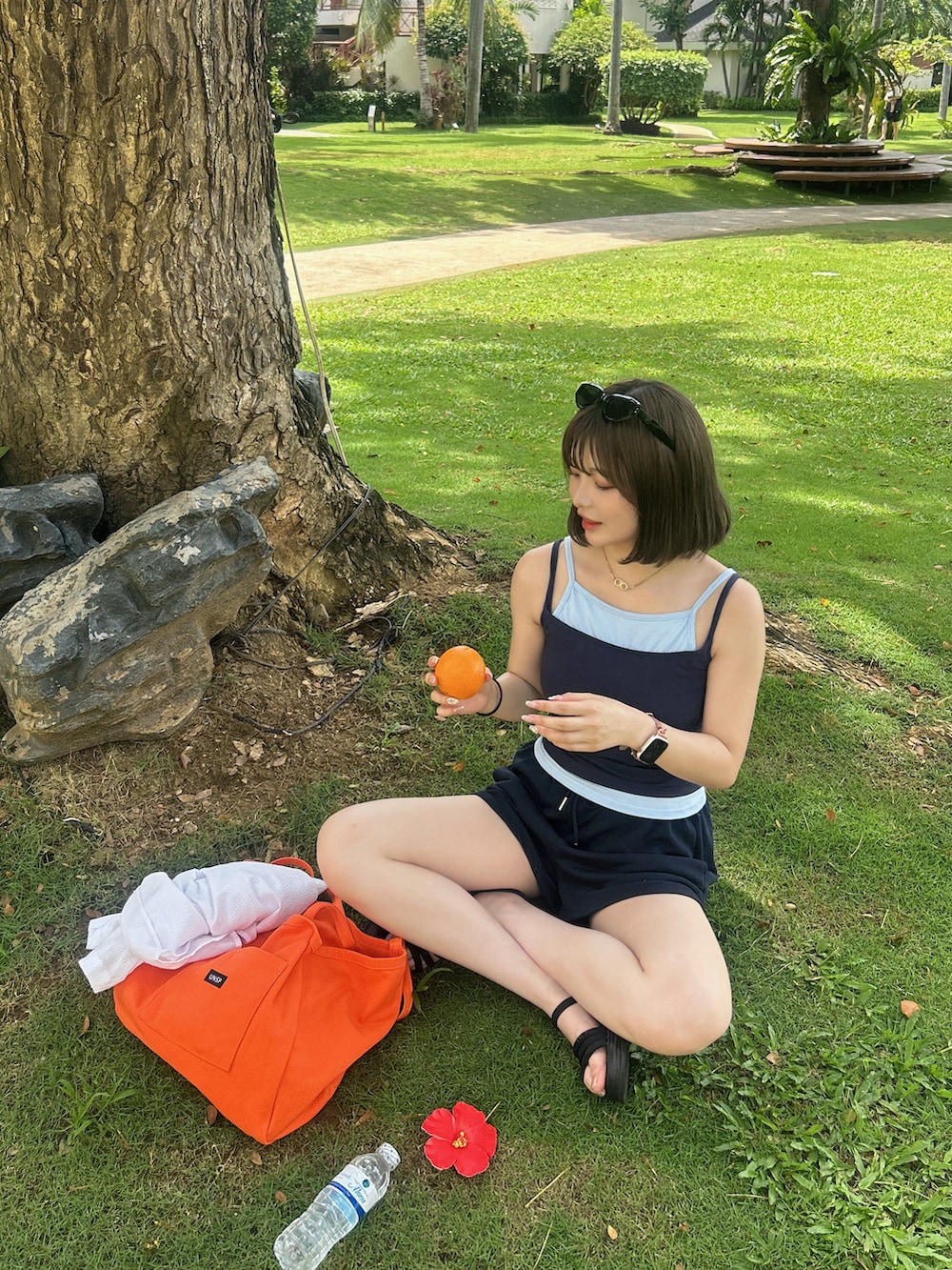 ブルー系のキャミソール、オレンジ系のトートバッグを着用したレディースの夏コーディネートの3枚目の写真