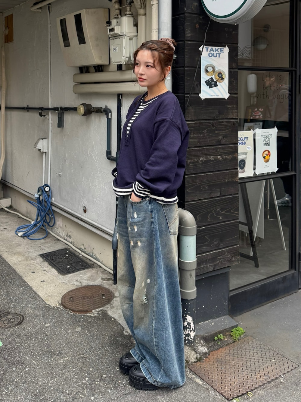 ブラック系のスニーカー、ブルー系のデニムパンツ、ブルー系のニット/セーターを着用したレディースの春コーディネートの2枚目の写真