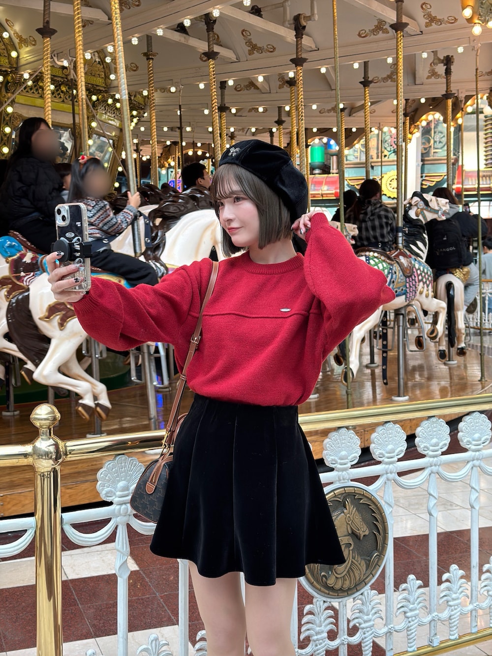 レッド系のニット/セーター、ブラック系のスカート、ブラウン系のハンドバッグを着用したレディースの冬コーディネートの5枚目の写真