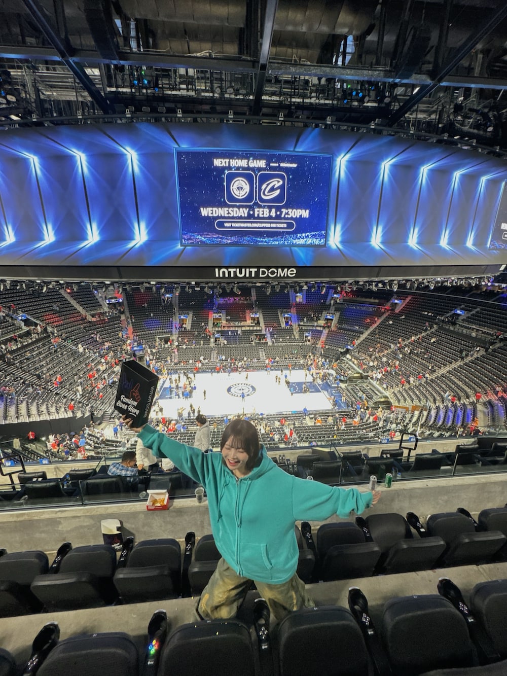 グリーン系のパーカー、ホワイト系のスニーカー、ブルー系のデニムパンツを着用したレディースの冬コーディネートの5枚目の写真