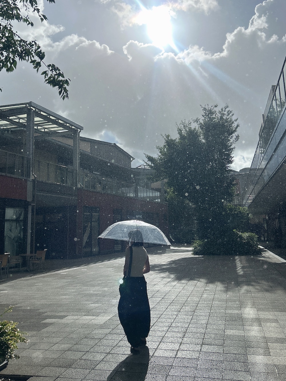 ブラック系のスウェットパンツ、ホワイト系のトップス、ブラック系のショルダーバッグを着用したレディースの夏コーディネートの4枚目の写真