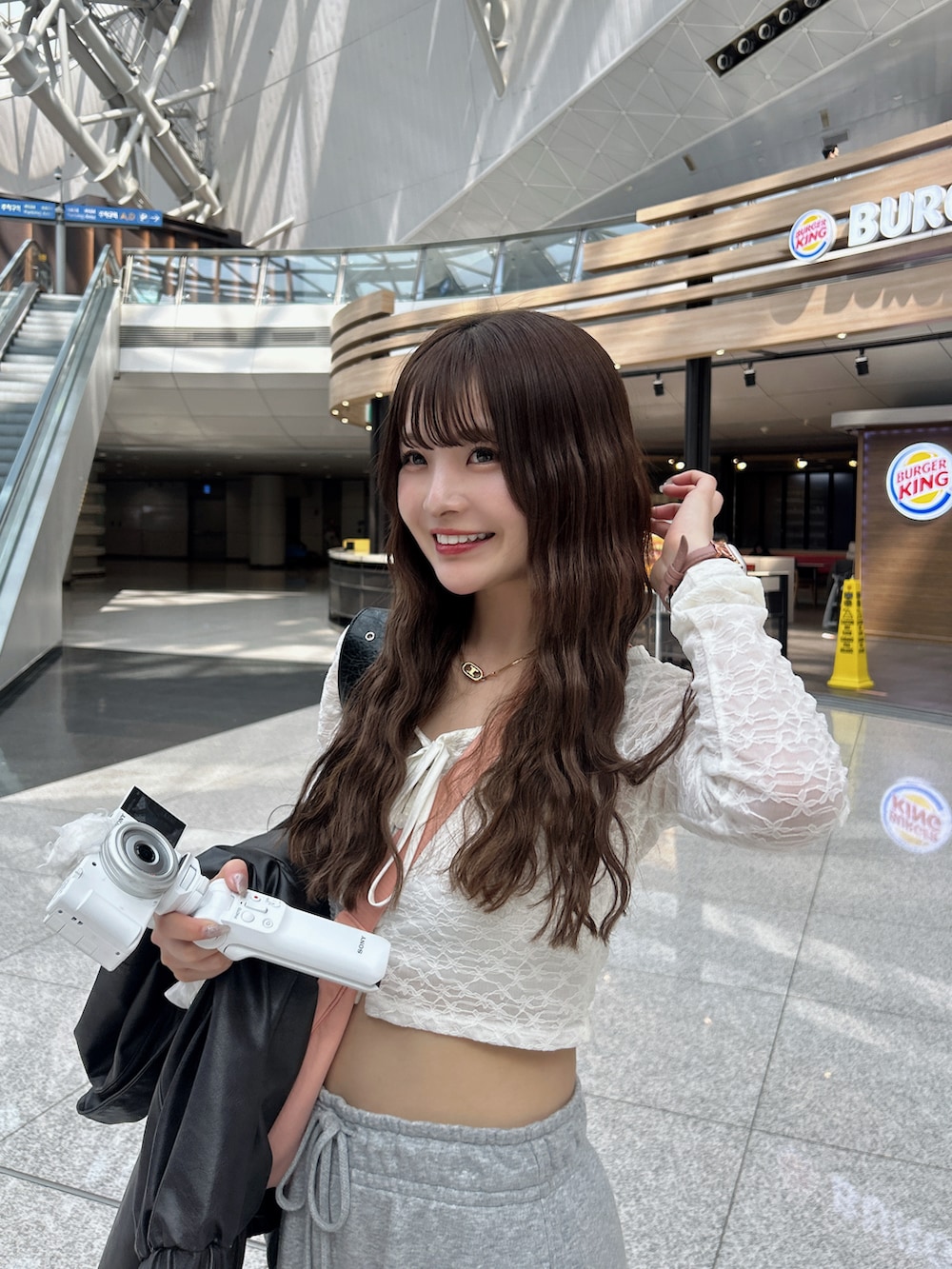 ピンク系のショルダーバッグ、ピンク系のスーツケース/キャリーバッグ、ピンク系のスニーカーを着用したレディースの春コーディネートの3枚目の写真