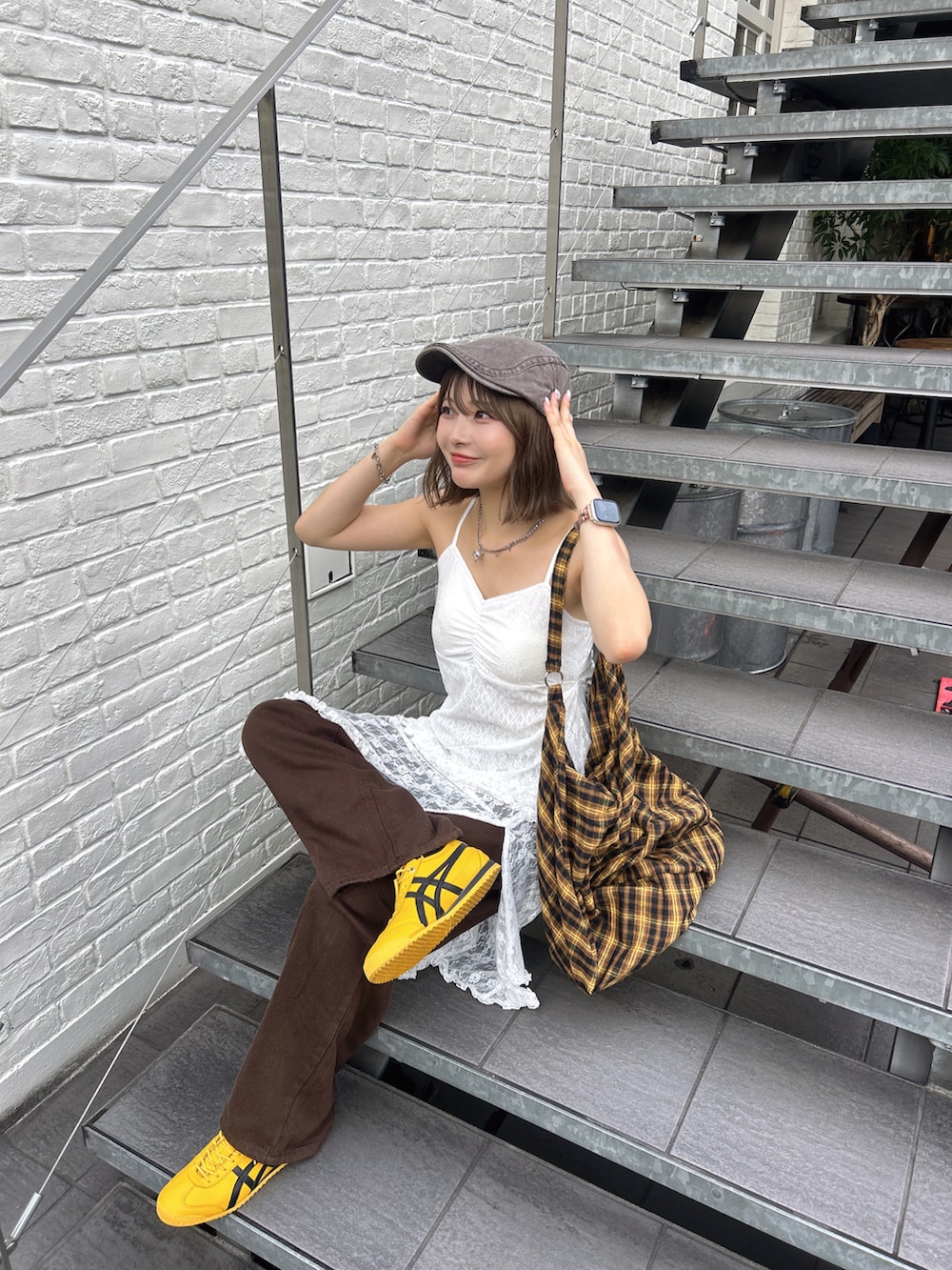 イエロー系のショルダーバッグ、ホワイト系のワンピース、イエロー系のスニーカーを着用したレディースの夏コーディネートの4枚目の写真