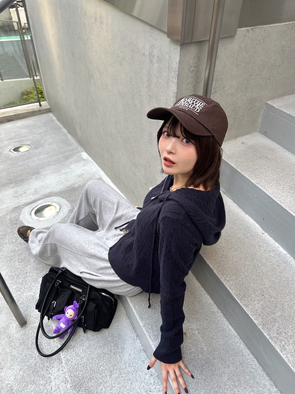 ブラウン系のスニーカー、ブラック系のトートバッグ、ブラウン系のベルトを着用したレディースの秋コーディネートの2枚目の写真