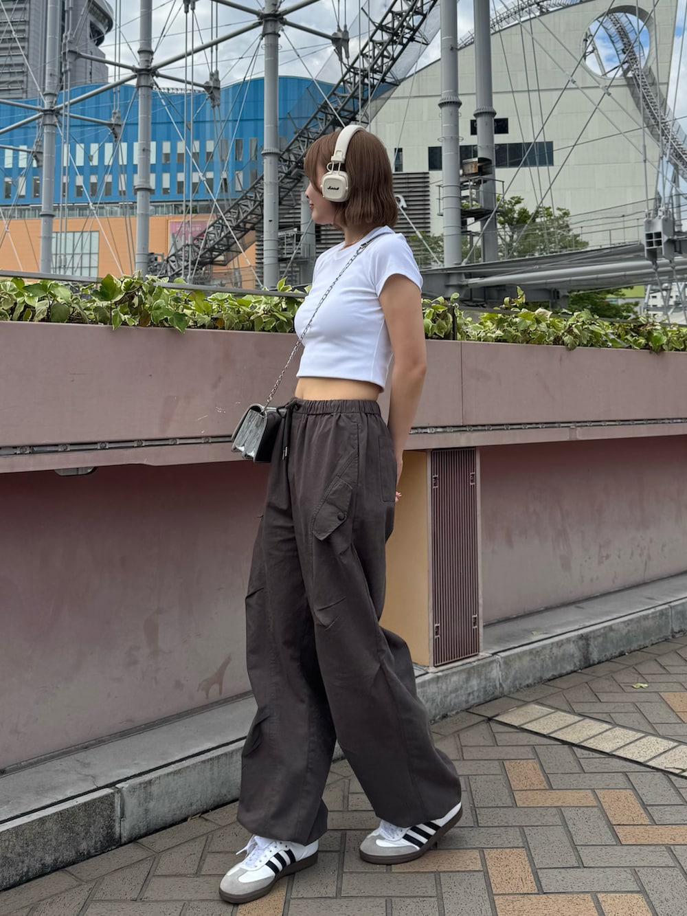 ホワイト系のTシャツ/カットソー、ブラック系のシューズアクセサリー、ホワイト系のスニーカーを着用したレディースの夏コーディネートの2枚目の写真