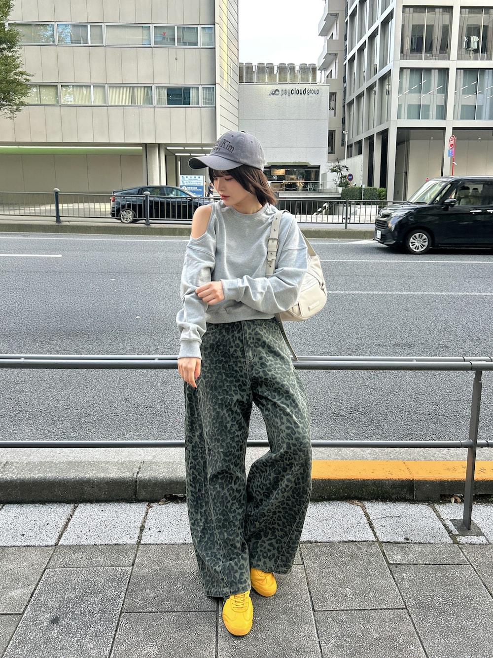 ブルー系のデニムパンツ、イエロー系のスニーカー、ホワイト系のバッグを着用したレディースの秋コーディネートの3枚目の写真