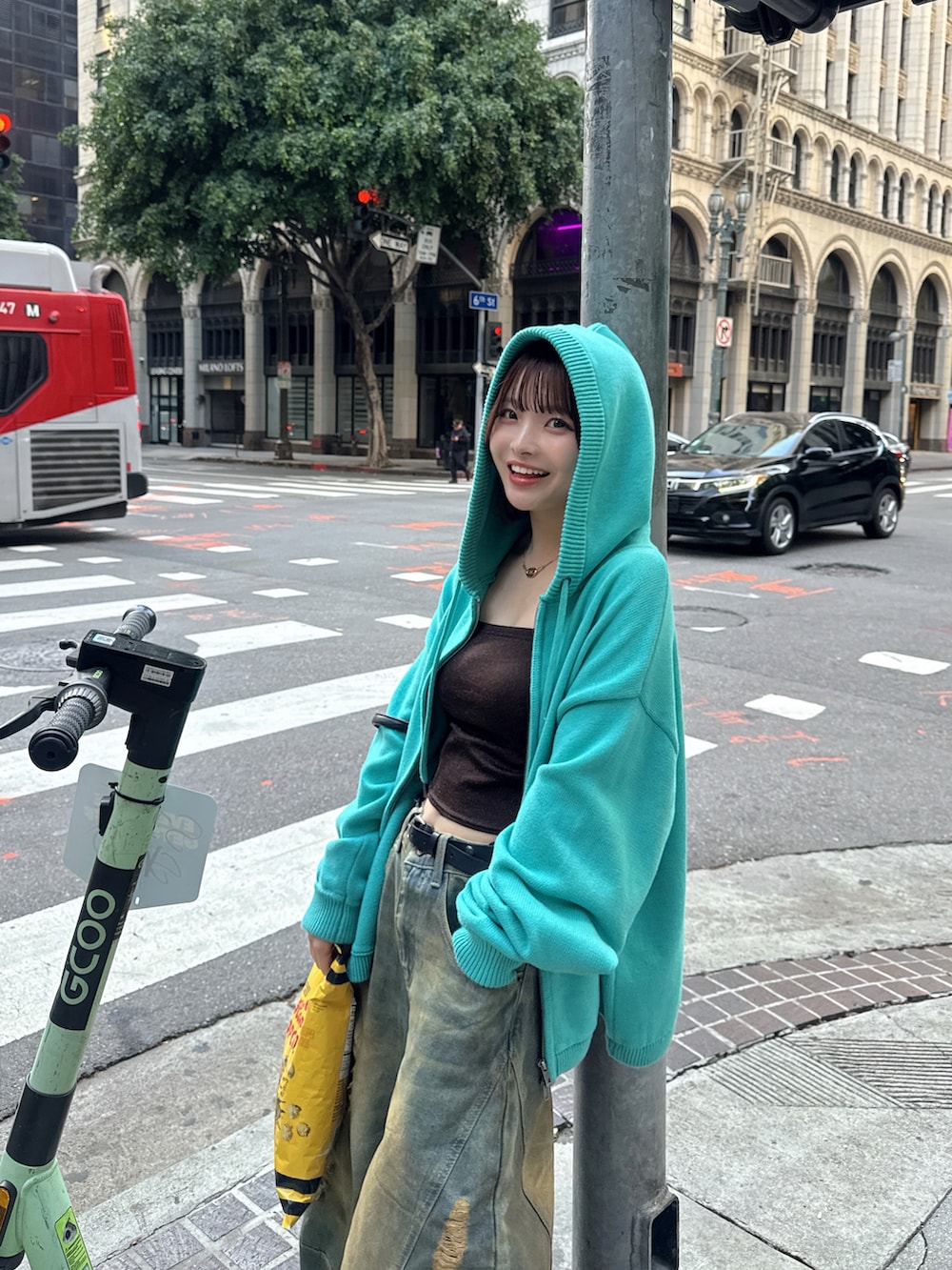 グリーン系のパーカー、ホワイト系のスニーカー、ブルー系のデニムパンツを着用したレディースの冬コーディネートの3枚目の写真