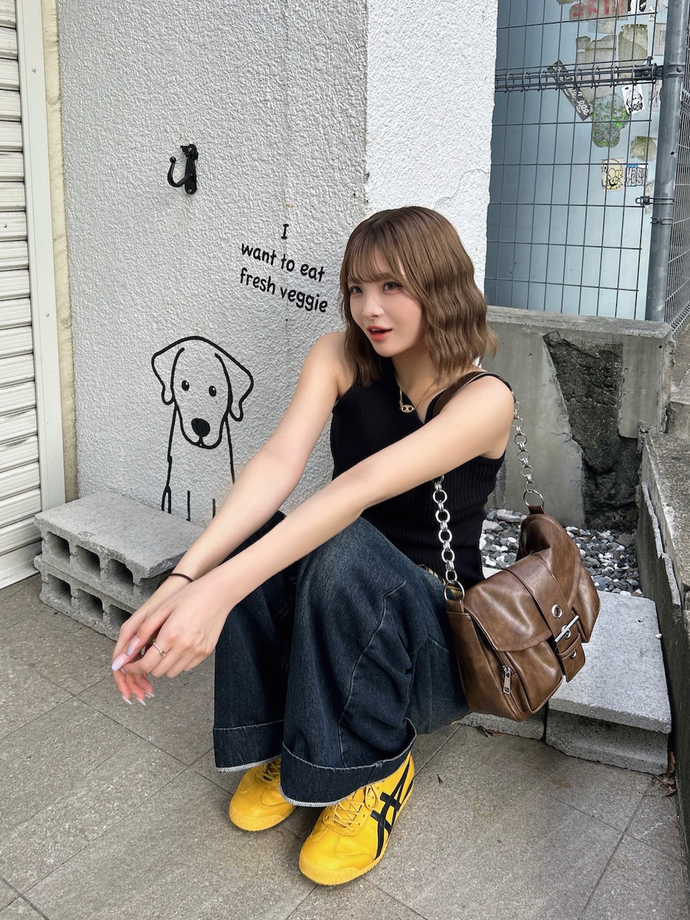 イエロー系のスニーカー、ブラウン系のハンドバッグ、ブラック系のタンクトップを着用したレディースの夏コーディネートの4枚目の写真