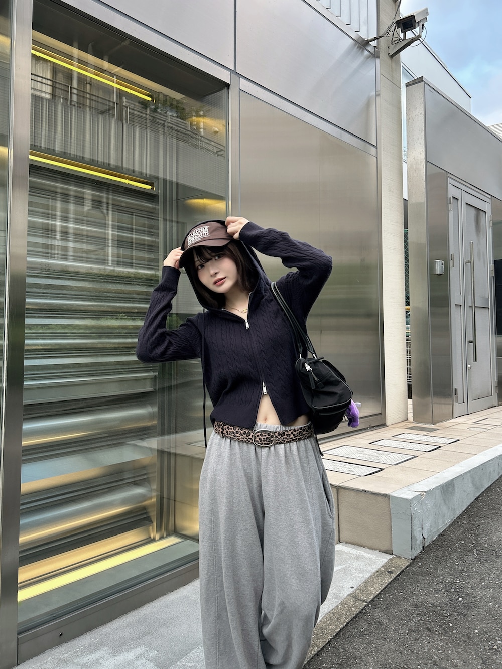 ブラウン系のスニーカー、ブラック系のトートバッグ、ブラウン系のベルトを着用したレディースの秋コーディネートの3枚目の写真