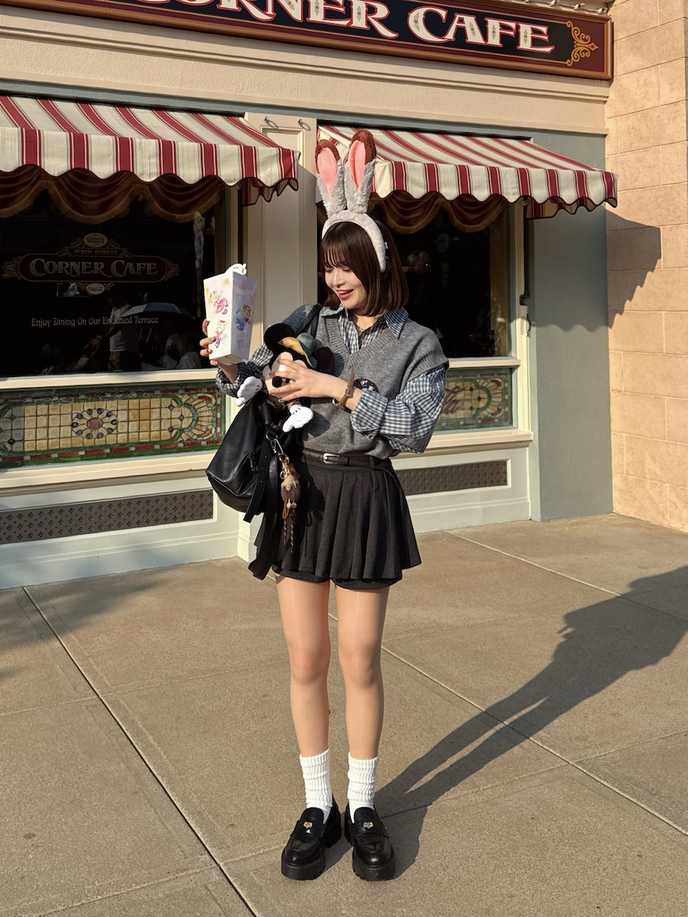 グレー系のベスト、ブルー系のシャツ/ブラウス、ブラック系のローファーを着用したレディースの冬コーディネートの5枚目の写真