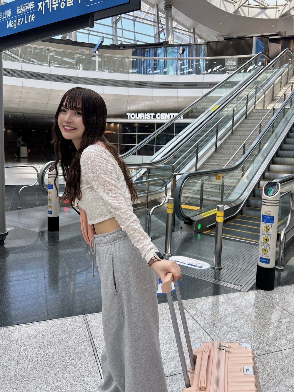 ピンク系のショルダーバッグ、ピンク系のスーツケース/キャリーバッグ、ピンク系のスニーカーを着用したレディースの春コーディネートの4枚目の写真