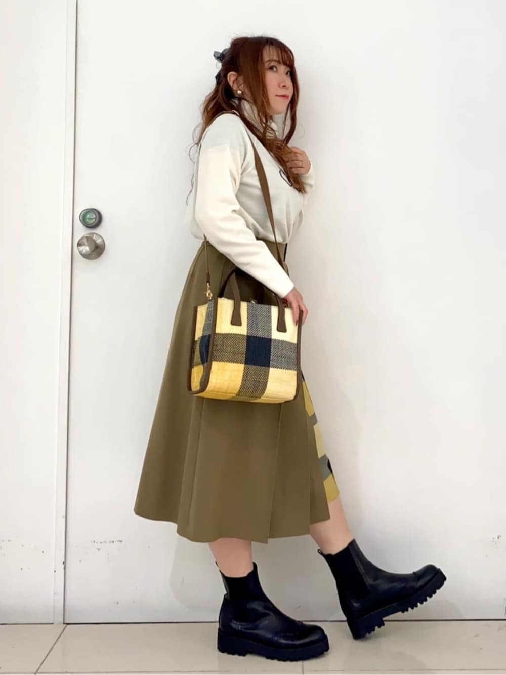 ブラック系のブーツ、ブルー系のピーコート、イエロー系のショルダーバッグを着用したレディースの秋コーディネートの3枚目の写真