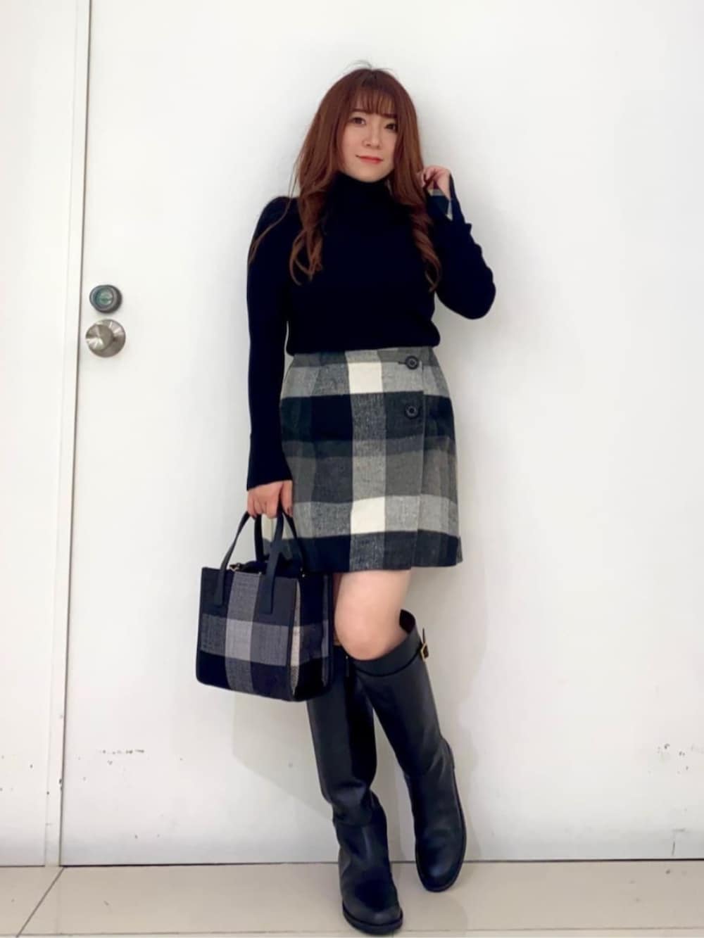 ブラック系のブーツ、ブラック系のショルダーバッグ、グレー系のベストを着用したレディースの秋コーディネートの2枚目の写真