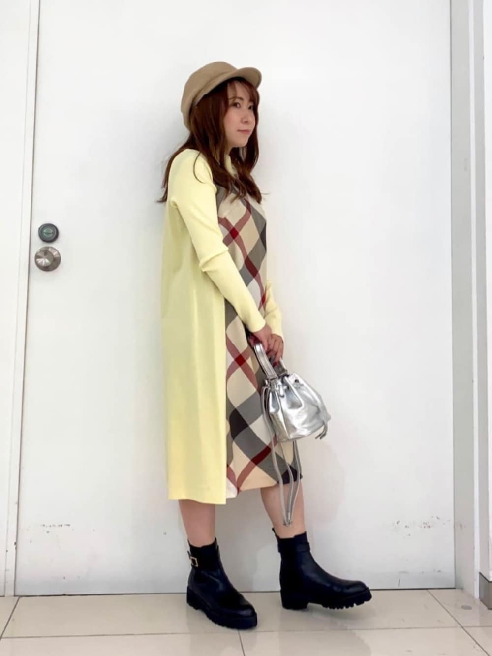 ブラック系のブーツ、イエロー系のワンピース、シルバー系のショルダーバッグを着用したレディースの夏コーディネートの2枚目の写真