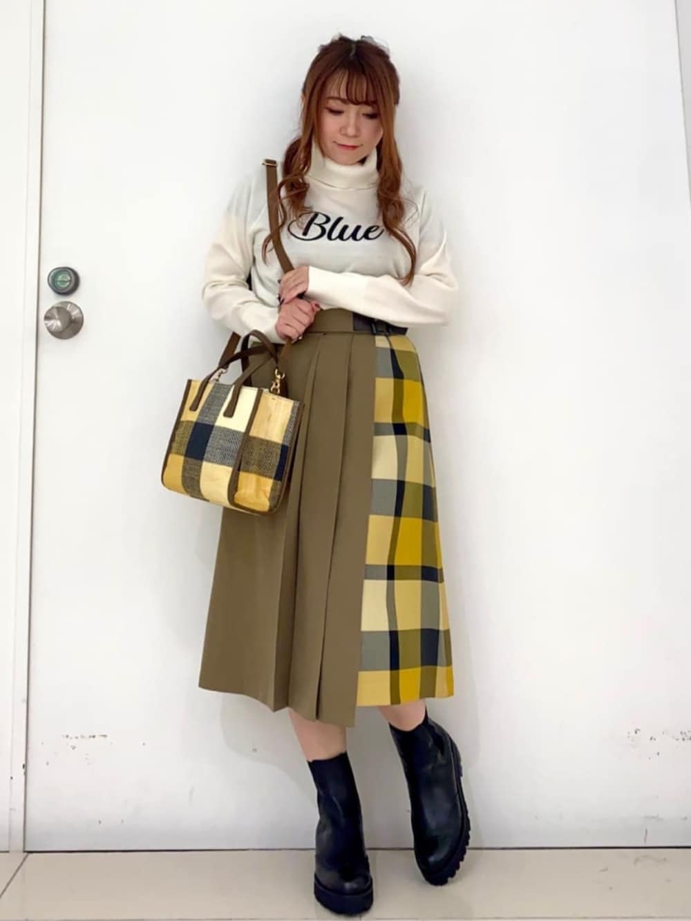 ブラック系のブーツ、ブルー系のピーコート、イエロー系のショルダーバッグを着用したレディースの秋コーディネートの2枚目の写真