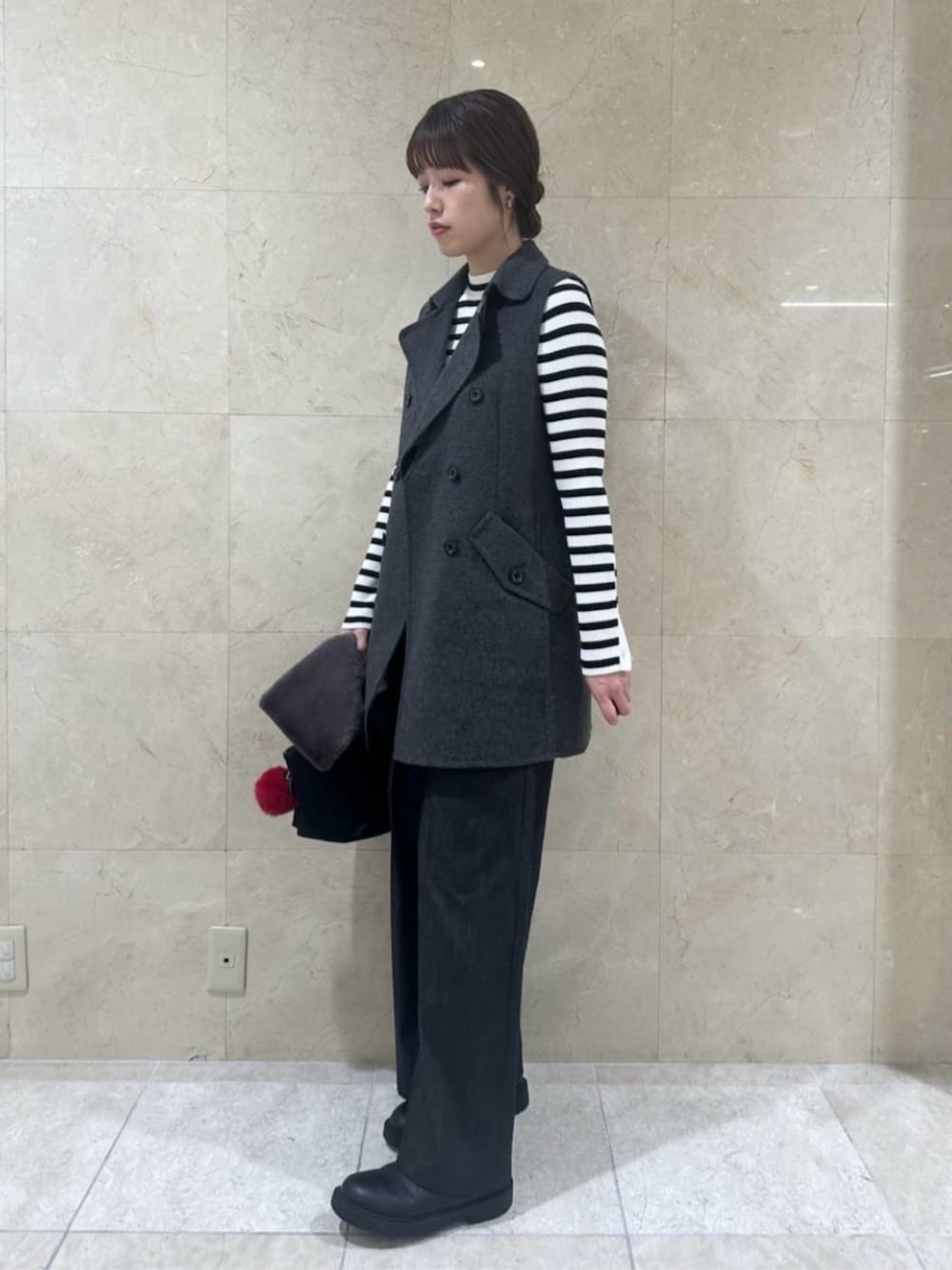 ブラック系のその他パンツ、ブラック系のハンドバッグ、グレー系のベストを着用したレディースの秋コーディネートの2枚目の写真