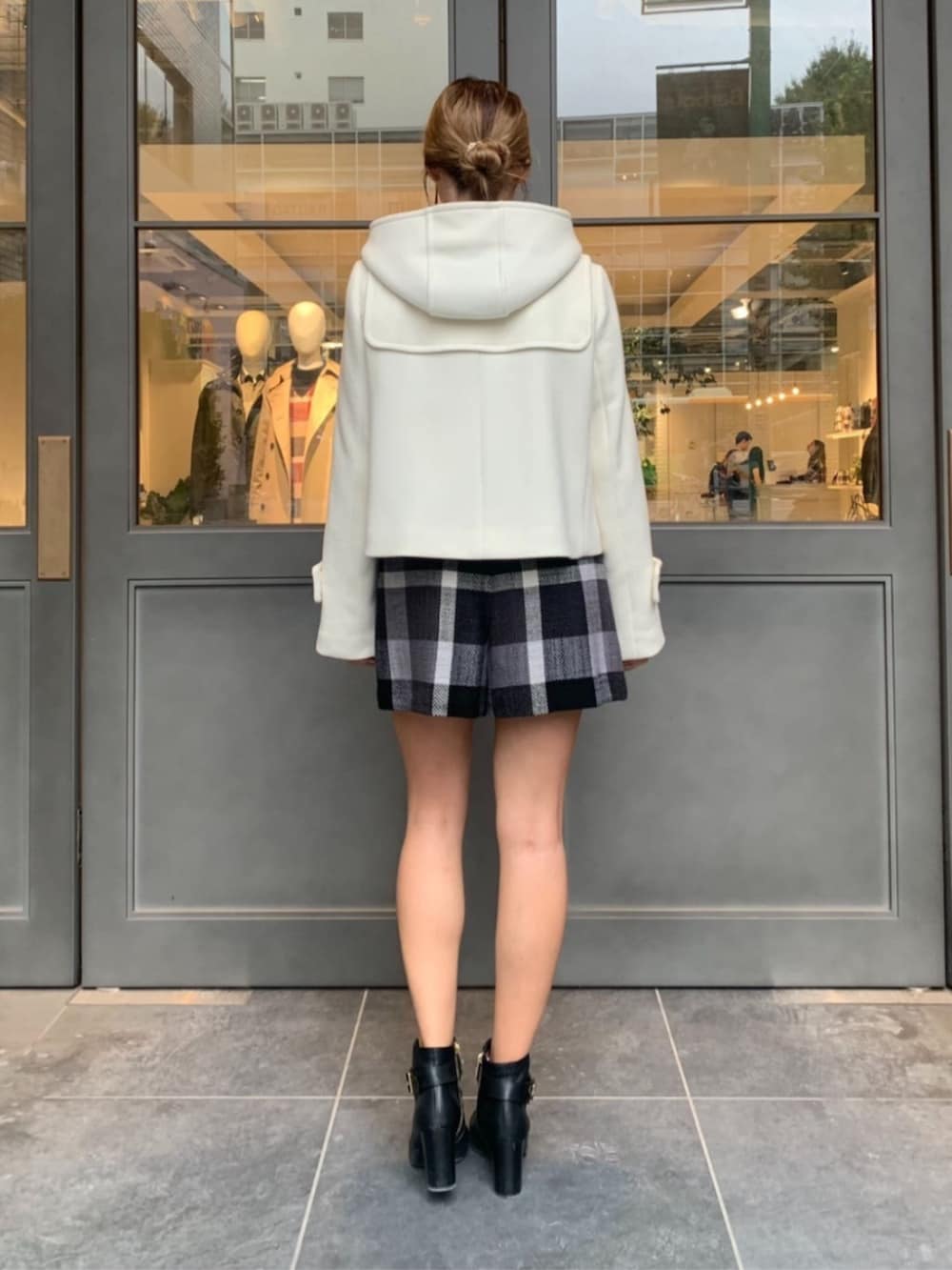 ホワイト系のダッフルコート、ブラック系のその他パンツを着用したレディースの秋コーディネートの2枚目の写真